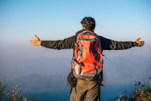 Man traveling with backpack hiking in mountains