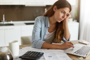 Picture of thoughtful focused young housewife studying loan agreement, searching for information on